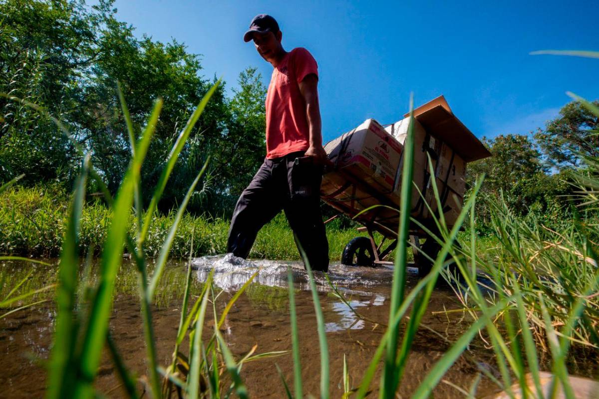 Los trocheros en carretilla cobran entre 15.000 y 20.000 pesos por llevar bolsos y paquetes por esos caminos clandestinos. Foto: Camilo Suárez
