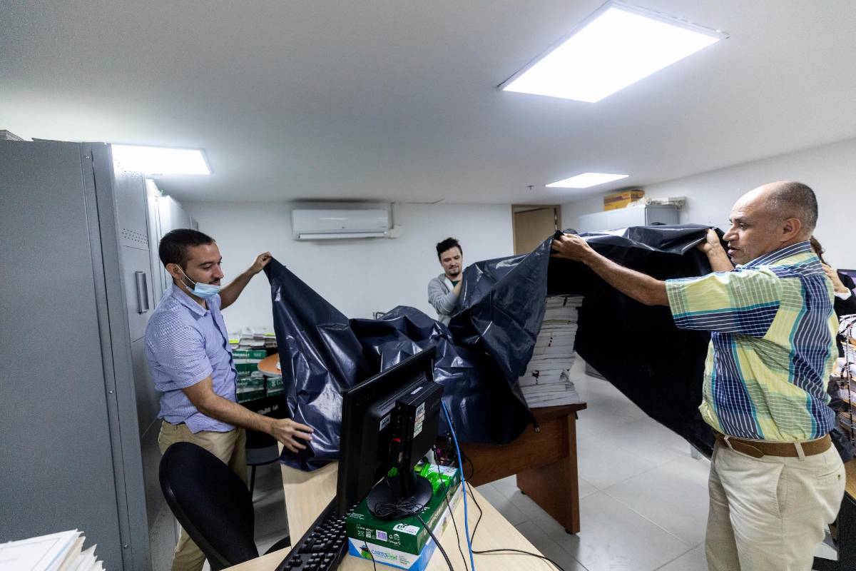 Cuando comienza a llover las labores se detienen mientras los funcionarios cubren con plástico sus elementos de trabajo. FOTO CAMILO 