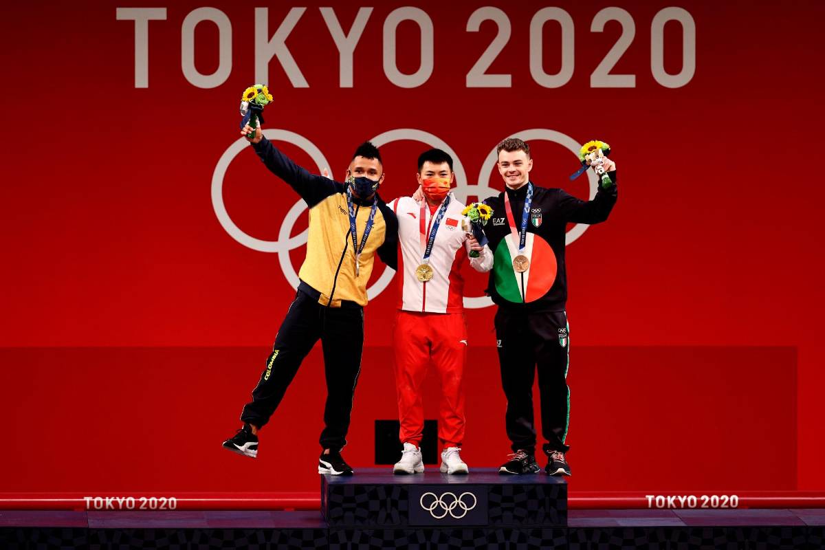 El medallista de plata Luis Javier Mosquera Lozano del Equipo de Colombia, el medallista de oro Lijun Chen del Equipo de China y el medallista de bronce Mirko Zanni del Equipo de Italia posan durante la ceremonia de entrega de medallas para Levantamiento de pesas. Foto Getty Images