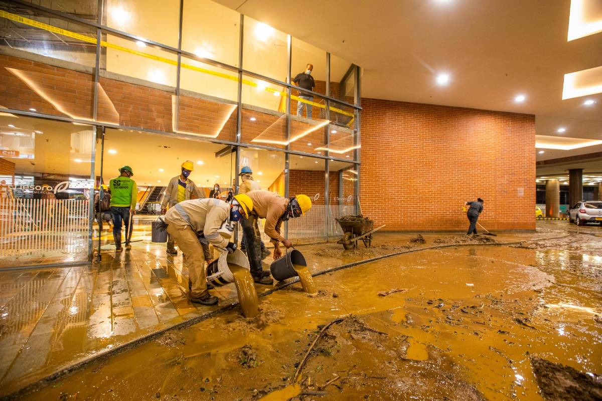 El centro comercial El Tesoro fue uno de los más afectados, los trabajadores de los almacenes trataron de sacar el agua y el lodo que los inundó. FOTO CARLOS VELASQUEZ