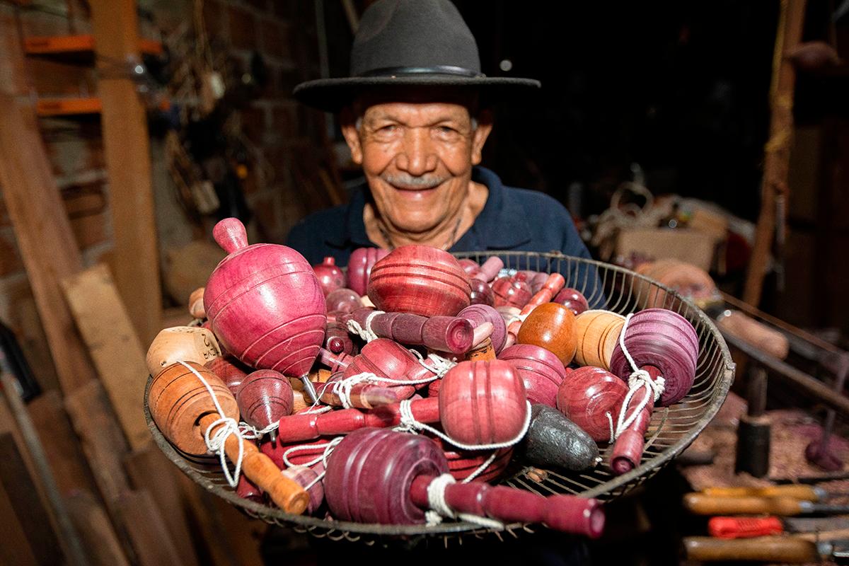 Don Antonio con su habilidad natural y acompañado de su torno, no solo fabrica trompos sino también pirinolas y yoyos, entre otros juegos tradicionales. Foto: Esneyder Gutiérrez