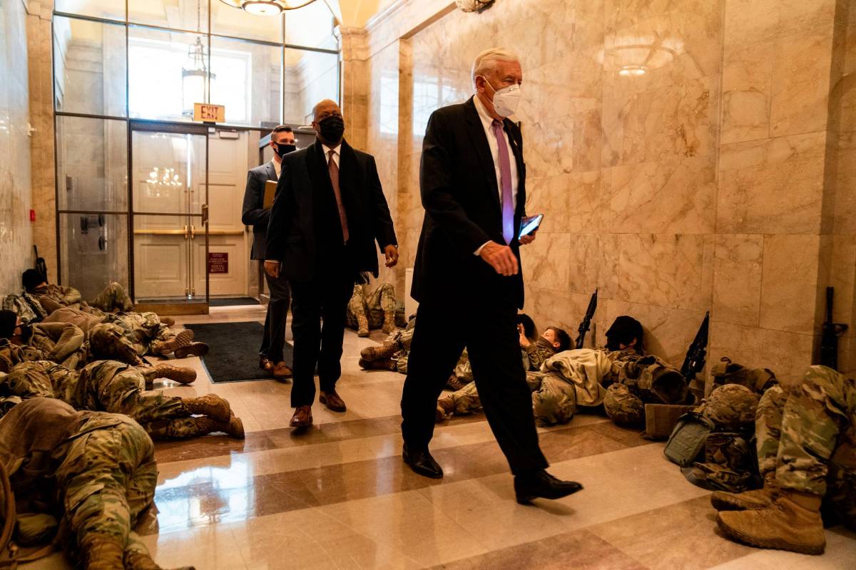 Miembros de la Guardia Nacional de los Estados Unidos duermen en los pasillos del Capitolio para prevenir nuevos desmanes, horas antes del debate por el juicio político a Donald Trump por la invasión de este recinto por parte de sus seguidores. Fotos: Kent Nishimura (Los Angeles Times) vía Getty.