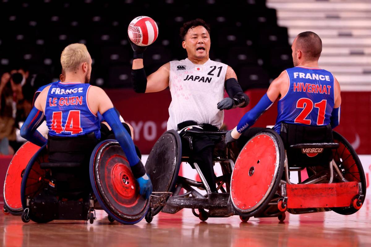 El japonés Yukinobu Ike lanza el balón mientras los franceses Corentin le Guen y Jonathan Hivernat miran durante la fase de grupos del partido de rugby en silla de ruedas del grupo A entre Francia y Japón. Foto AFP