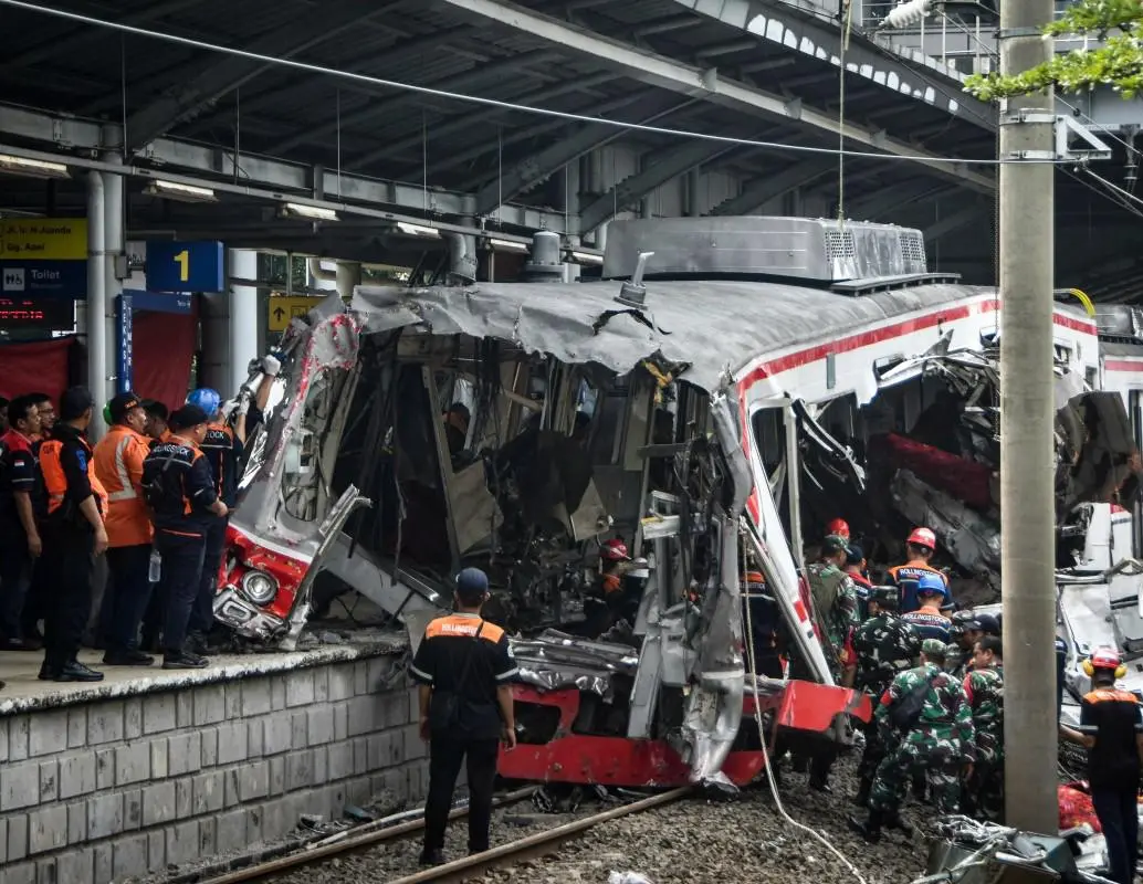 Equipos de rescate y trabajadores inspeccionan los restos de los trenes involucrados en el choque ocurrido en la estación Bekasi Timur, en las afueras de Yakarta, Indonesia. FOTO: AFP. 
