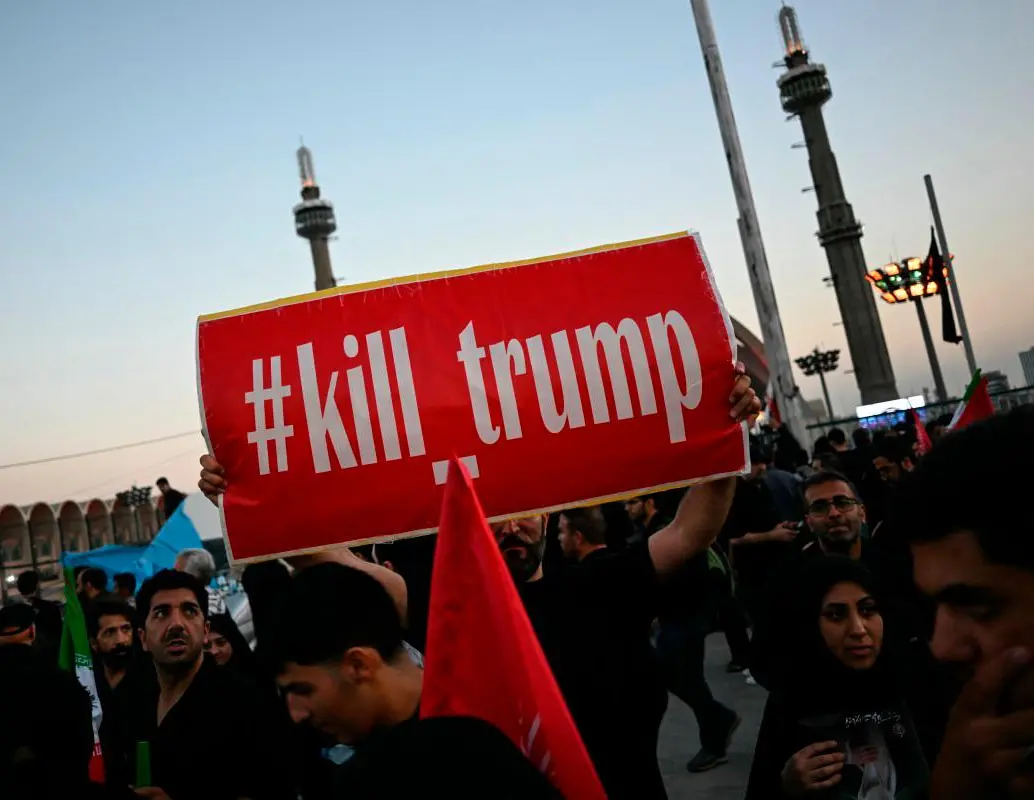 Un hombre sostiene una pancarta que pide venganza contra el presidente de Estados Unidos mientras los dolientes se reúnen para rendir homenaje al líder supremo de Irán, el ayatolá Ali Jamenei. FOTO: AFP