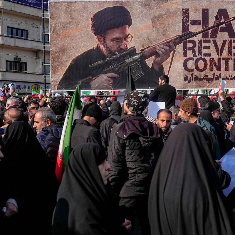 Una pancarta que representa al ayatolá Mojtaba Jamenei, el nuevo Líder Supremo de Irán e hijo del fallecido líder ayatolá Alí Jamenei, es exhibida mientras se le muestra empuñando un arma en la plaza Enghelab (Revolución) en Teherán, el 11 de marzo de 2026, mientras los asistentes se reúnen para los funerales de comandantes del Cuerpo de la Guardia Revolucionaria Islámica (CGRI), el ejército y otros fallecidos en los primeros días de los ataques de Estados Unidos e Israel contra Irán. El Líder Supremo de Irán, el ayatolá Alí Jamenei, murió en los ataques del 28 de febrero, y desde entonces el conflicto ha escalado en ataques de represalia por toda la región. (Foto de Khoshiran / Middle East Images vía AFP)