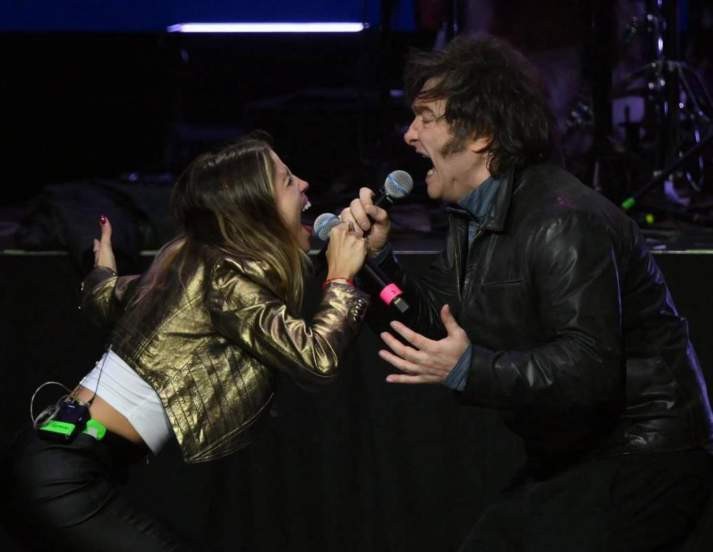 Javier Milei (derecha), canta con la cantante argentina Ana Tamagno durante el lanzamiento de su nuevo libro, “La construcción del milagro”. FOTO: AFP