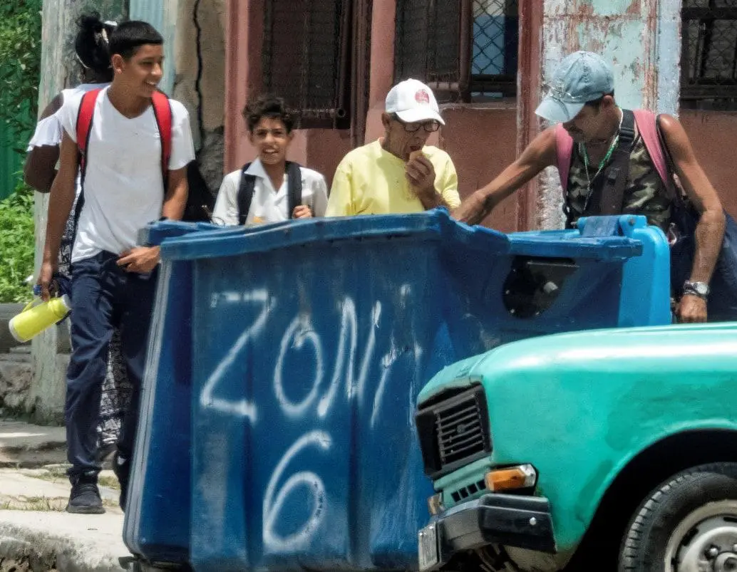 Un hombre hurga en un contenedor de basura en La Habana. La mendicidad en Cuba está asociada a la pobreza extrema, el abandono familiar y problemas de salud mental. FOTO: AFP