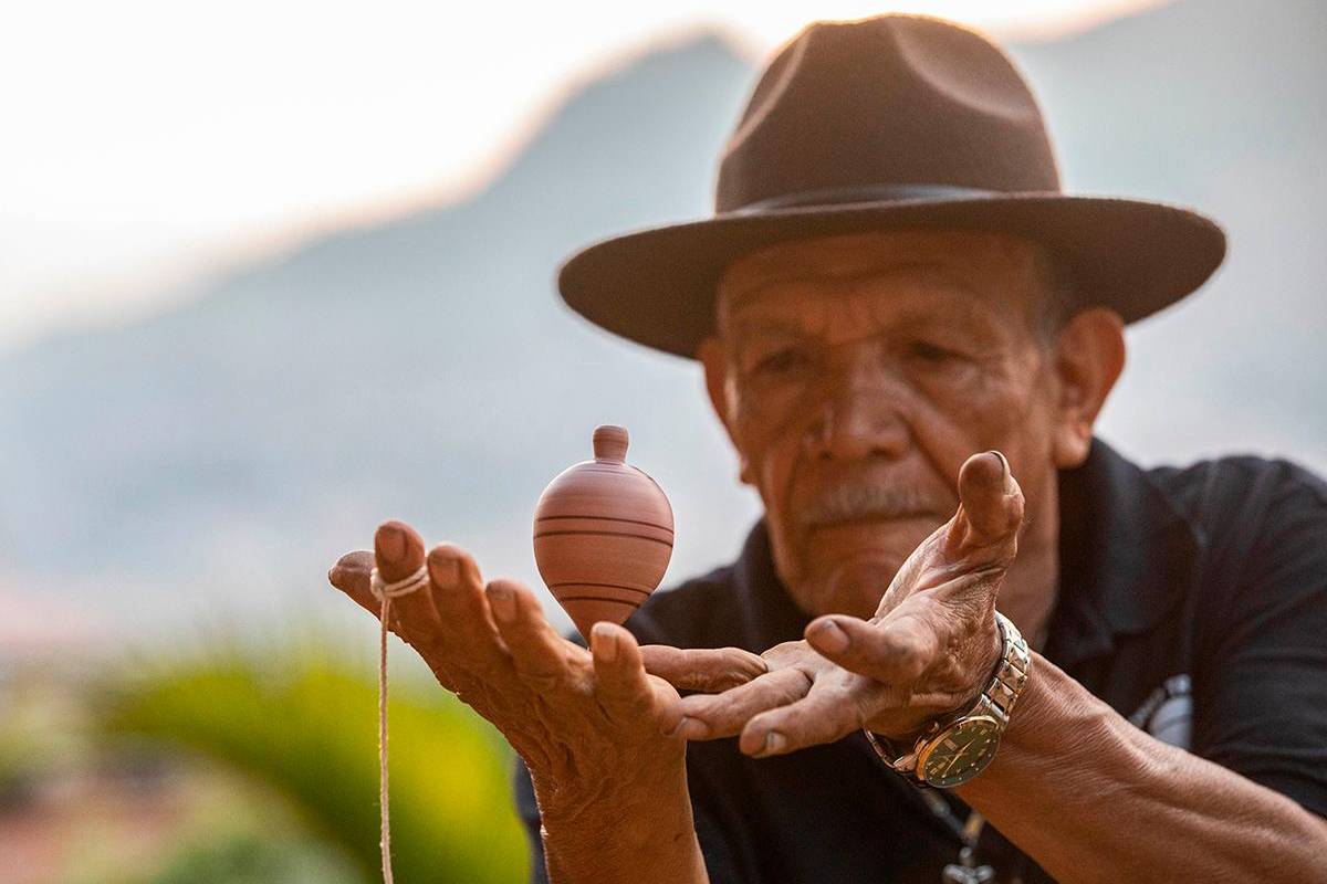 Con 40 años de experiencia, ha perfeccionado sus habilidades para dominar diferentes técnicas y trucos con los trompos de todos los tamaños que crea en su taller. Foto: Esneyder Gutiérrez