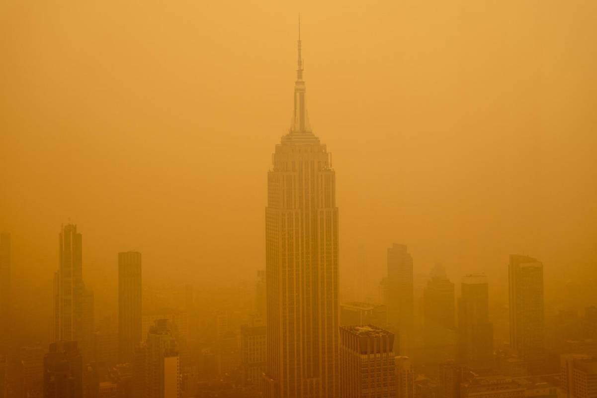Un smog anaranjado causado por los incendios forestales de Canadá envolvió a Nueva York el miércoles, oscureciendo sus rascacielos y haciendo que los residentes se pusieran tapabocas mientras las ciudades de la costa este de Estados Unidos emitían alertas por la calidad del aire. FOTO: GETTY
