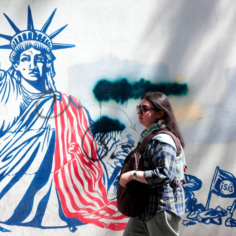 Una mujer camina junto a un mural antiestadounidense cerca de la antigua embajada estadounidense en Teherán. FOTO ATTA KENARE / AFP