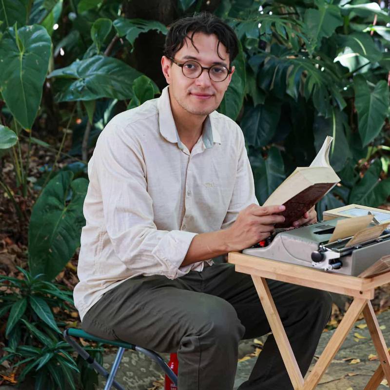 Este es Santiago Serna, de 29 años, quien escribe cartas de amor o de todo tipo en la Fiesta del Libro y la Cultura. El precio de las epístolas es un aporte voluntario. FOTO: Manuel Saldarriaga.