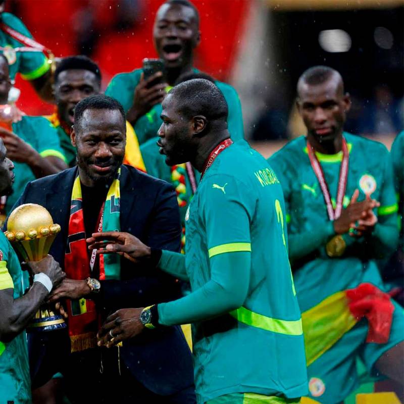 El técnico Pape Thiaw, junto a sus dirigidos y el trofeo durante la celebración del título ganado en la cancha ante Marruecos. FOTO GETTY 