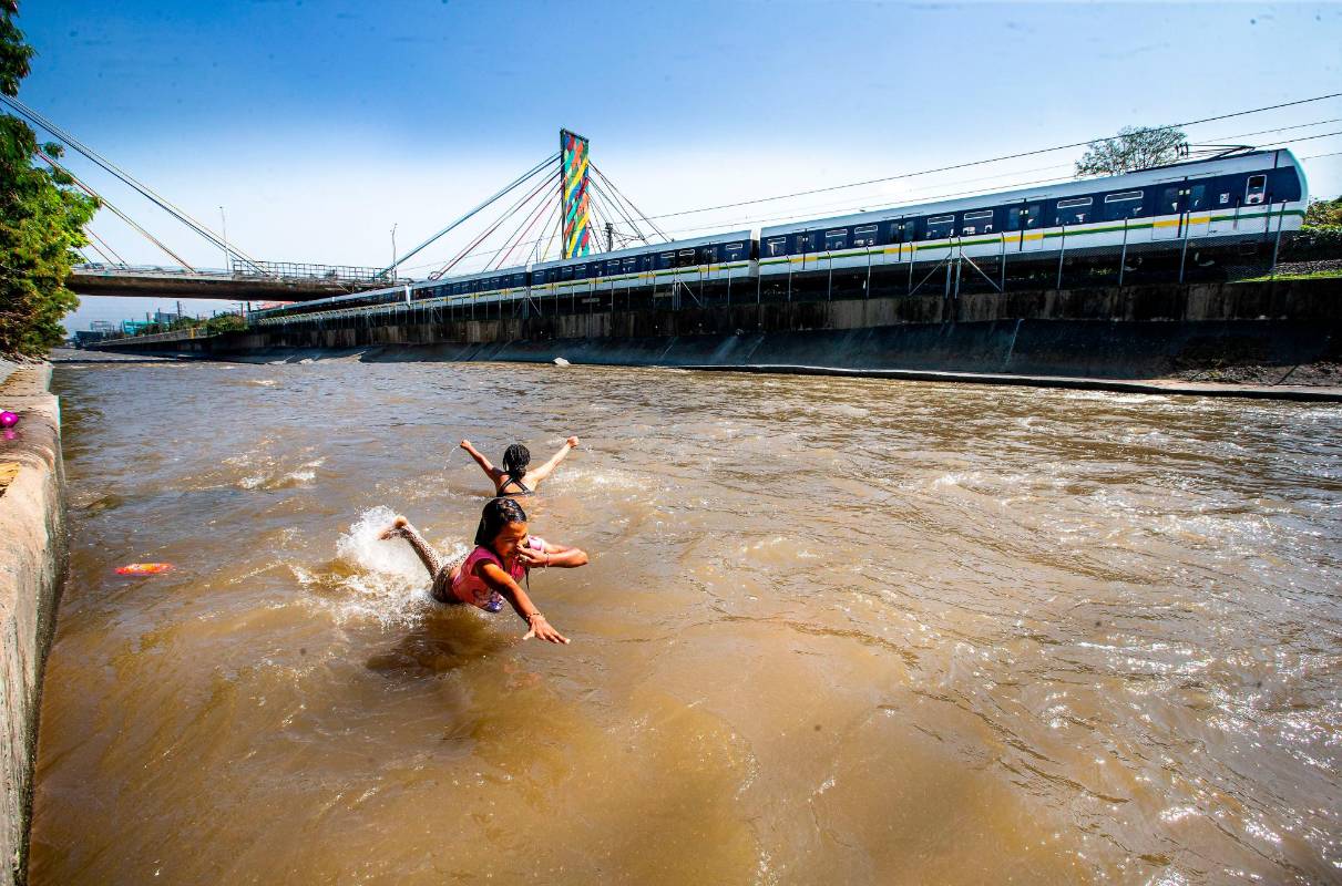 Grupo de niños migrantes de Venezuela se bañan y juegan en las sucias aguas del río Medellín. Foto: Esneyder Gutiérrez