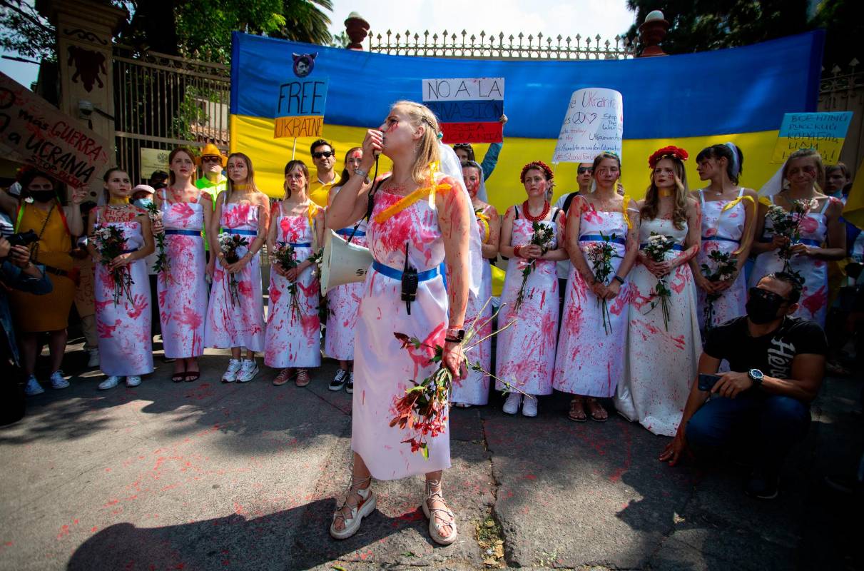 Mujeres de México vestidas de blanco y con pintura roja, simulan la sangre derramada en estos días de incursión rusa. Foto: Getty