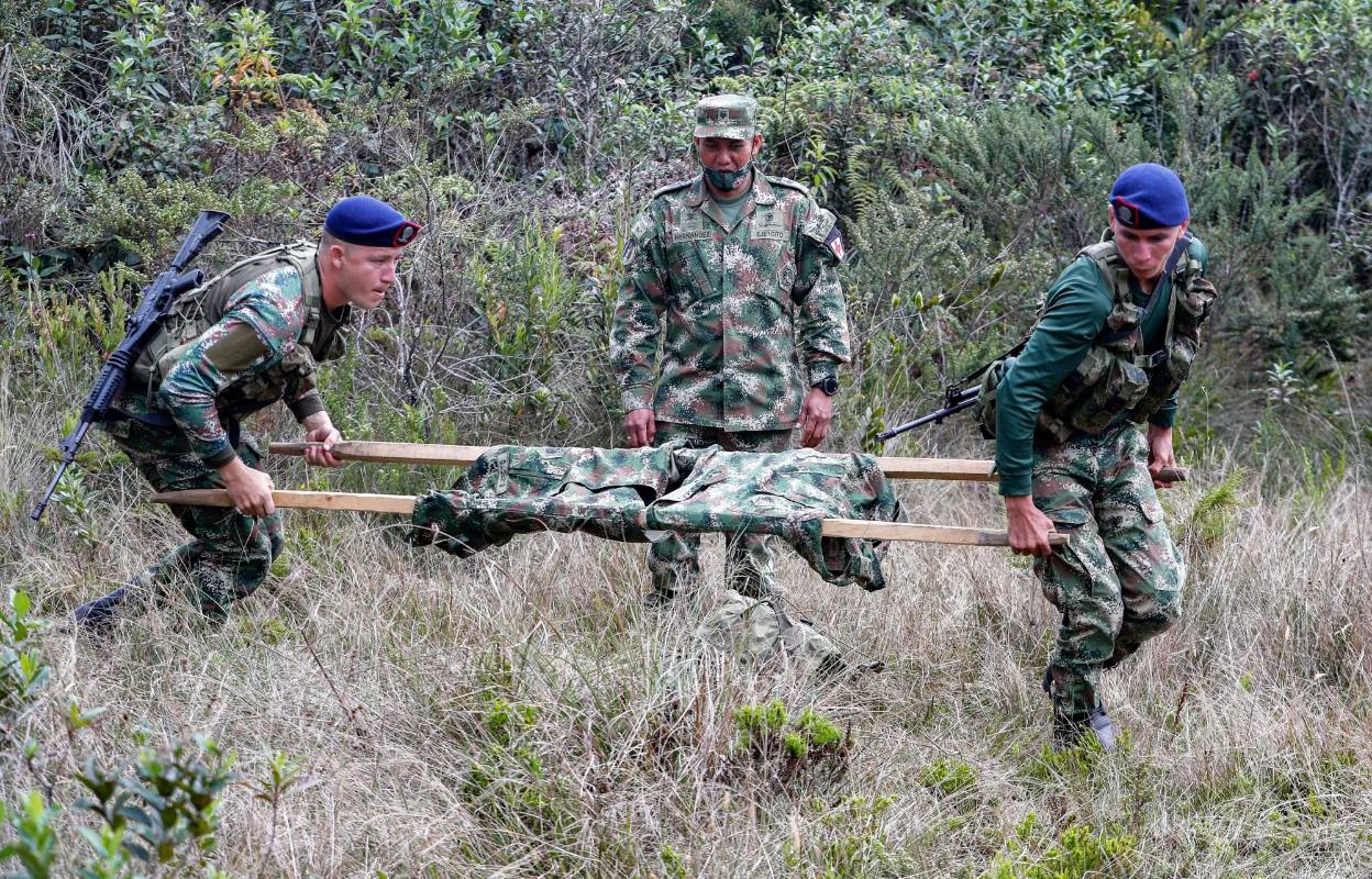 En medios de los combates también es necesario improvisar camillas artesanales para trasladar a los heridos. Foto: Manuel Saldarriaga Quntero.