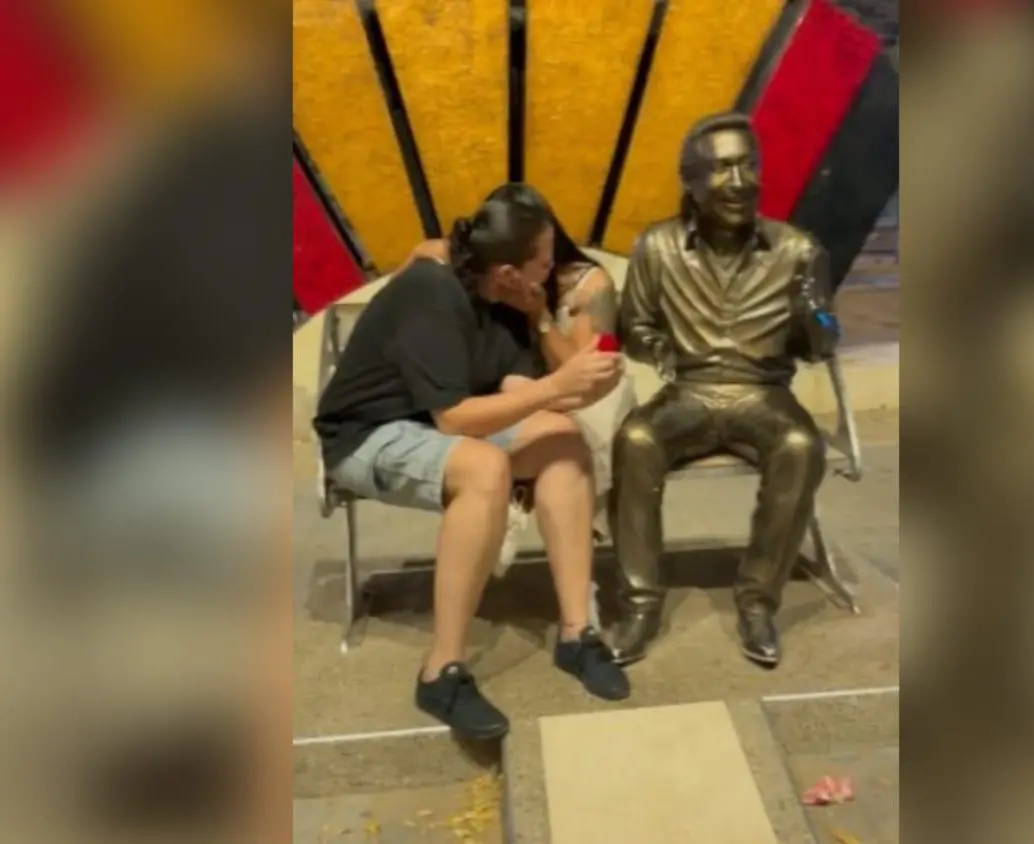 Una de las mujeres preparó la sorpresa con excusa de tomar una foto juntas al lado de la estatua. Imagen, captura de video. 