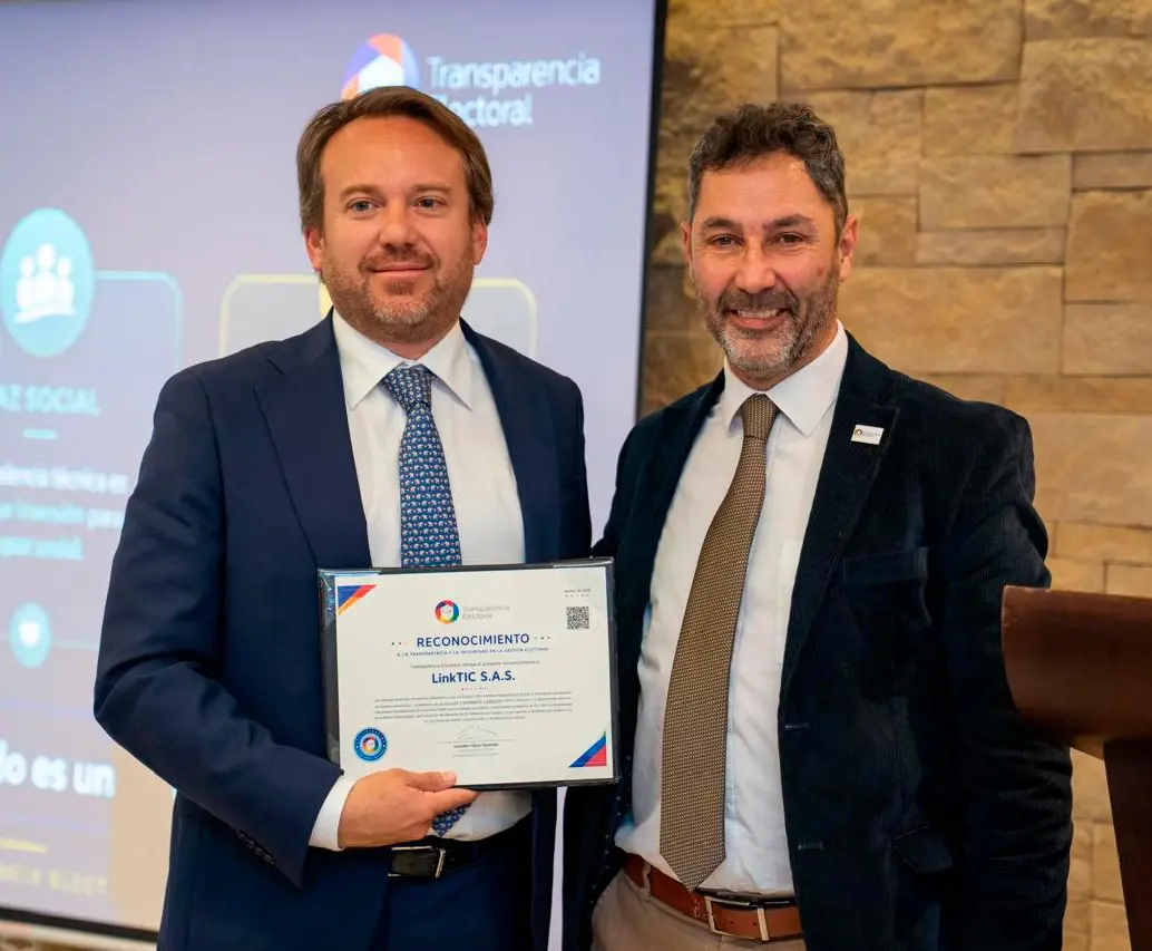 Leandro Querido, director ejecutivo de Transparencia Electoral (Der.), durante la entrega, en el norte de Bogotá, del reconocimiento a LinkTIC Unión Temporal Actores Electorales 2026. 