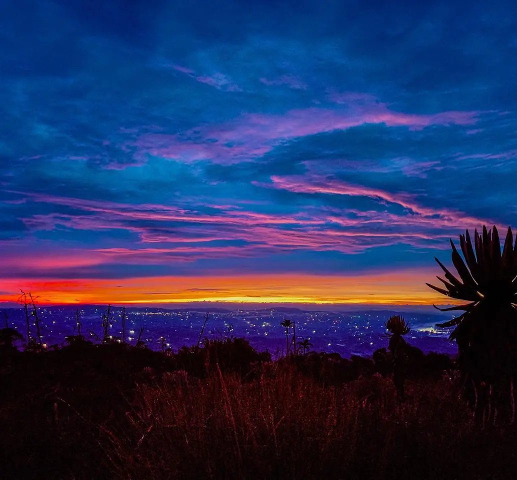 Amanecer en el Páramo de Belmira a más de 3.300 metros de altura, con el cielo teñido de tonos rojos y rosados tras una noche de caminata. Foto: Cristina Rodriguez.