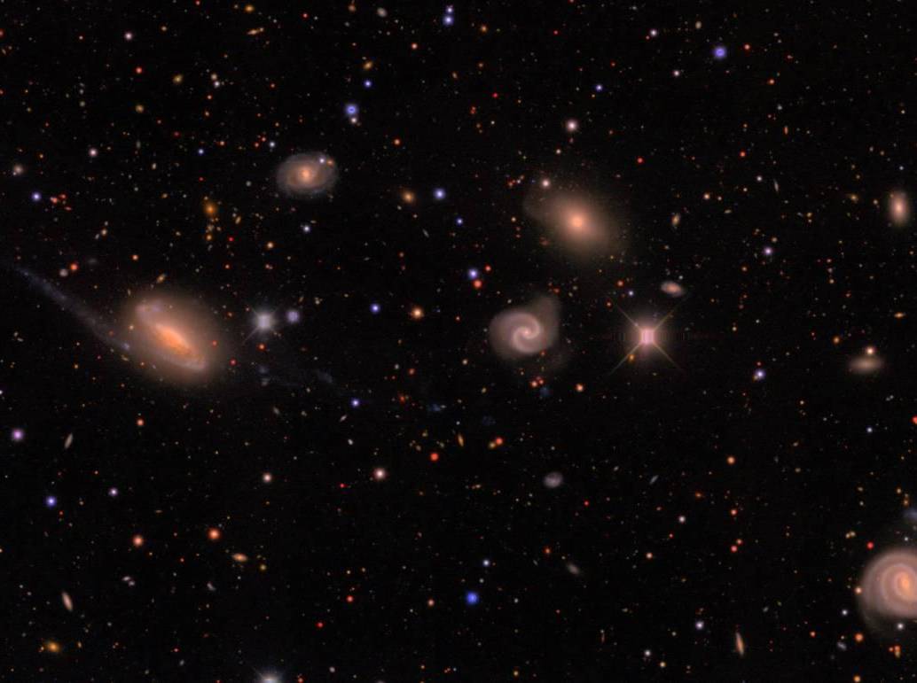 Imagen de DECam de un campo en la constelación austral de Lepus que muestra estrellas de la Vía Láctea (pequeños puntos de colores) y un grupo de galaxias (los objetos difusos de mayor tamaño) situado a unos 300 millones de años luz. FOTO Agencia SINC - Erin Sheldon
