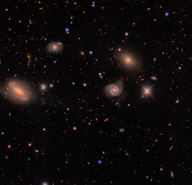 Imagen de DECam de un campo en la constelación austral de Lepus que muestra estrellas de la Vía Láctea (pequeños puntos de colores) y un grupo de galaxias (los objetos difusos de mayor tamaño) situado a unos 300 millones de años luz. FOTO Agencia SINC - Erin Sheldon