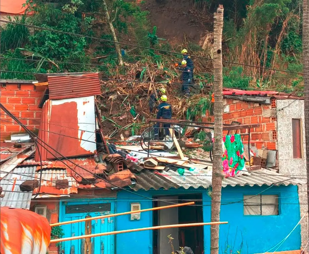 Autoridades y comunidad tratan de remover la tierra que cayó sobre la propiedad en el barrio La Unión, de Itagüí. FOTO: CORTESÍA