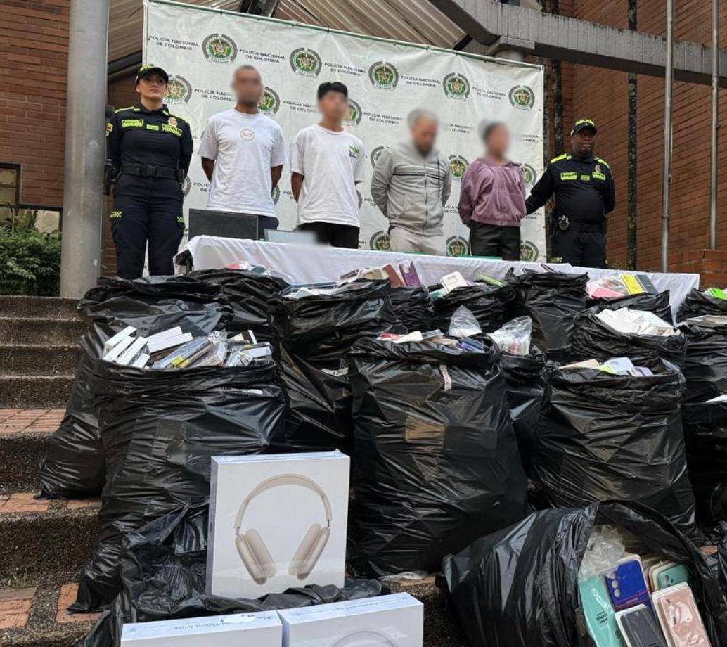 En las bolsas negras, todos los celulares y artículos recuperados e incautados. Al fondo, los cuatro capturados en el Opera. FOTO Policía Metropolitana. 