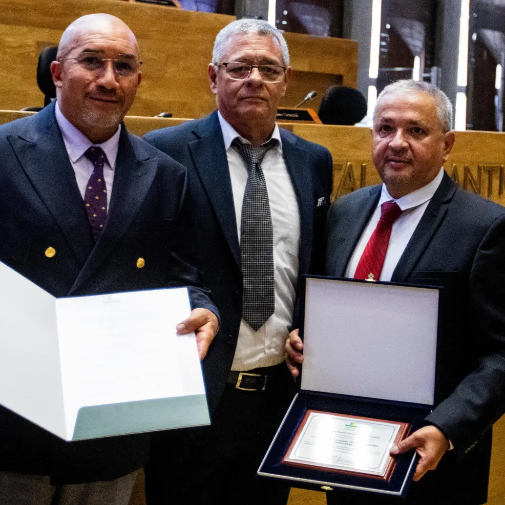 El diputado Carlos Humberto García entrega al gerente de Coopetraban, Manuel Mosquera Osorio y al presidente del Consejo de Administración, Álvaro Mejía Molina, la máxima distinción de la Asamblea de Antioquia. Crédito: Julio César Herrera