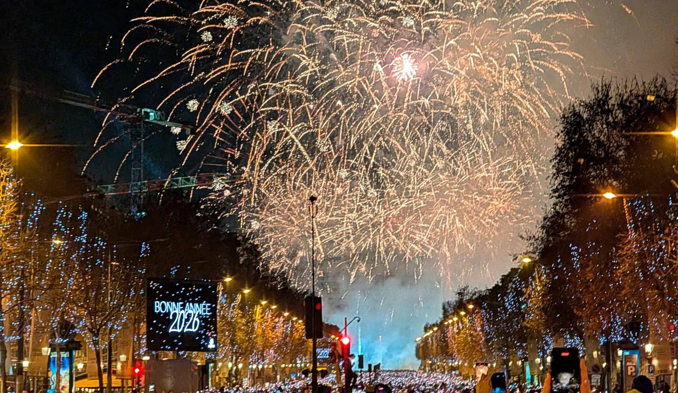 Un espectáculo de luces se proyecta sobre el Arco de Triunfo mientras los fuegos artificiales iluminan el cielo durante las celebraciones de Año Nuevo en los Campos Elíseos de París (Francia). Foto: Afp 