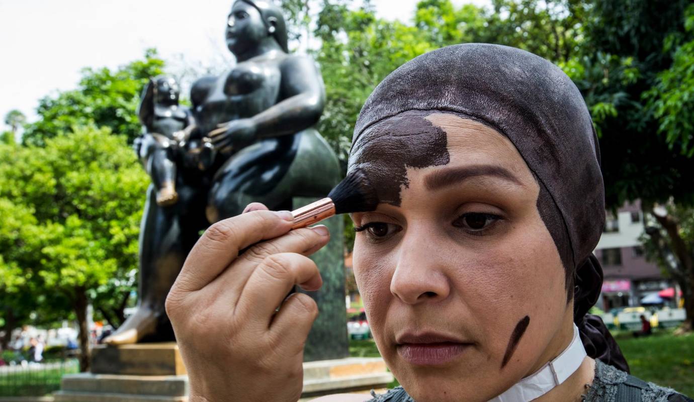 Primero se aplica protector solar. Luego se hecha pintura acrílica hasta que de el color cobrizo de las esculturas, duro 8 meses preparando, investigado y diseñando este personaje. Foto: Julio César Herrera.