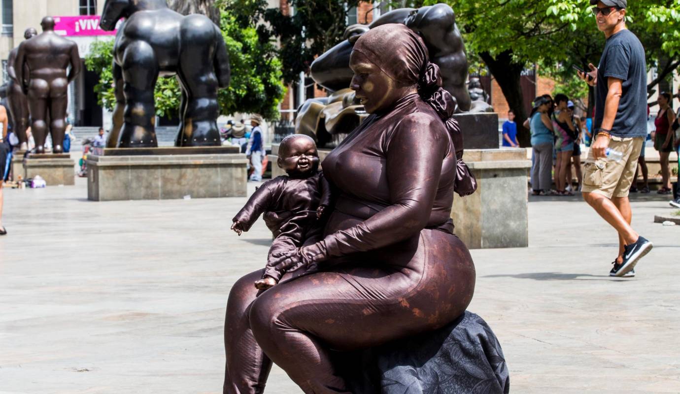 Mireya Terán quién emigró hace cinco años por la crisis de Venezuela, encontró en el arte la manera de sobrevivir en Medellín. Diseño un traje especial y ahora representa las esculturas de Botero, en esta imagen es la Maternidad. Foto: Julio César Herrera.