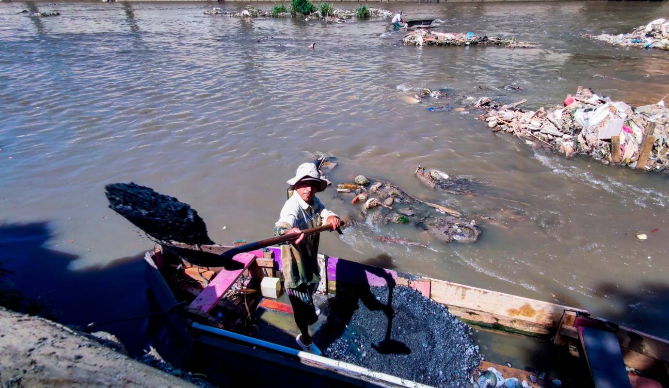 A la altura de la estación Caribe del metro, los areneros realizan este rudo y antiguo trabajo en medio de las aguas contaminadas y viendo pasar a su lado toda clase de basuras. Foto: Julio César Herrera