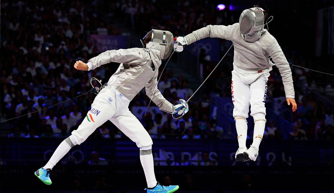 Krisztian Rabb, de Hungría (izq.) y Sangwon Park, de la República de Corea, compiten durante el partido por la medalla de oro en sable masculino por equipos. Foto: GETTY