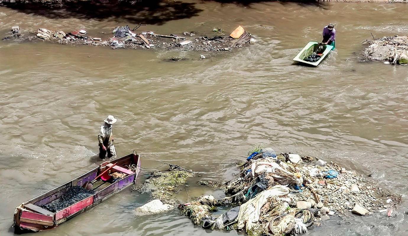 A la altura de la estación Caribe del metro, los areneros realizan este rudo y antiguo trabajo en medio de las aguas contaminadas y viendo pasar a su lado toda clase de basuras. Foto: Julio César Herrera