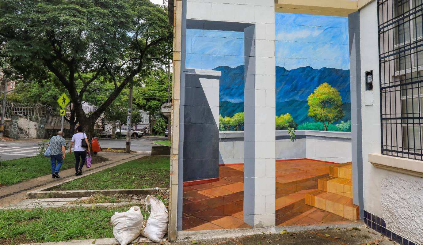 Arquitectura pintada: un viaje en el tiempo - Situado en la carrera 50 con la calle 64, este mural simula una casa colonial con una terraza y un paisaje de montañas y arcoíris, evocando la riqueza arquitectónica de Prado. Foto: Esneyder Gutiérrez. 