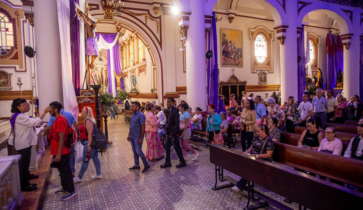 Tres servidoras, dos al frente del atrio, y una en un costado, imponían la cruz. Alrededor de 40 personas pasaban para recibir la señal, por minuto, lo que traduce que a cerca de 2.400 personas se la impusieron en solo una hora. Foto: Carlos Velásquez 