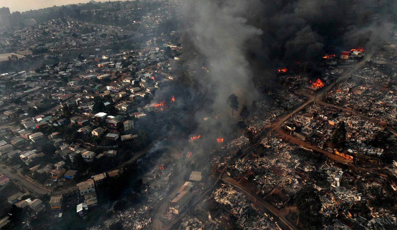 Los bomberos luchan para controlar las llamas que devoran los cerros y zonas urbanas. Foto: AFP