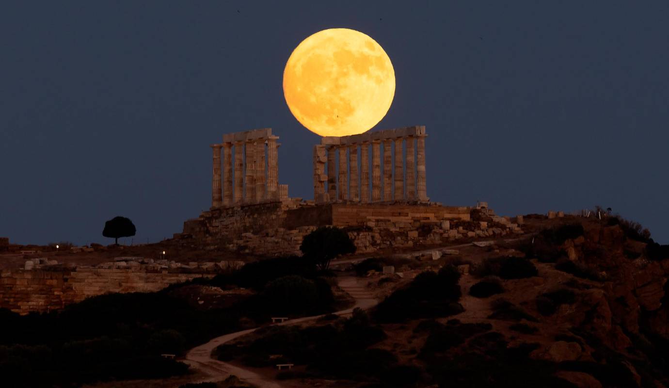 La luna llena se eleva detrás del antiguo templo griego de Poseidón en el cabo Sounion en Grecia. Foto: GETTY