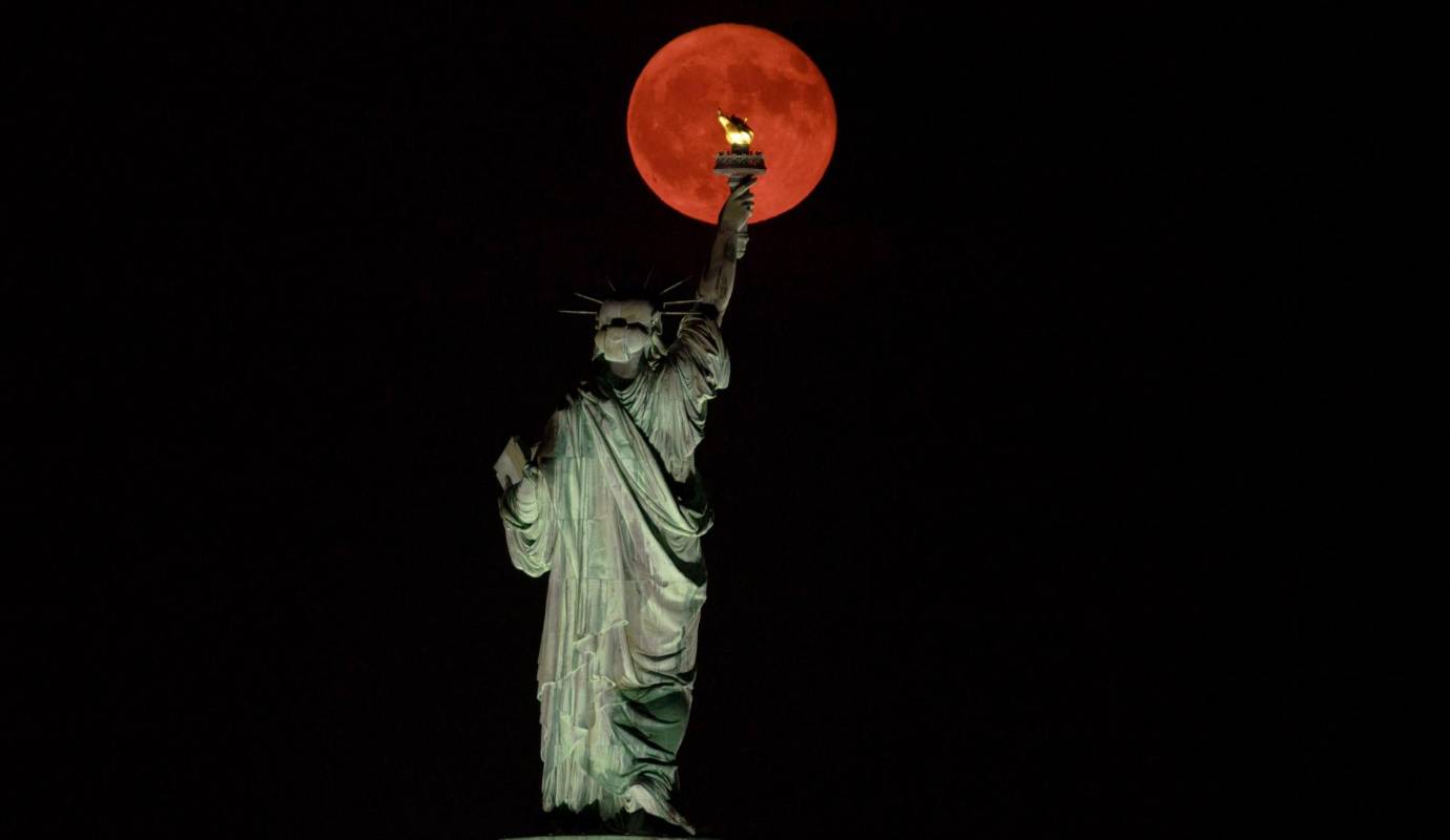 La Luna llena Buck se eleva detrás de la Estatua de la Libertad. Foto: GETTY