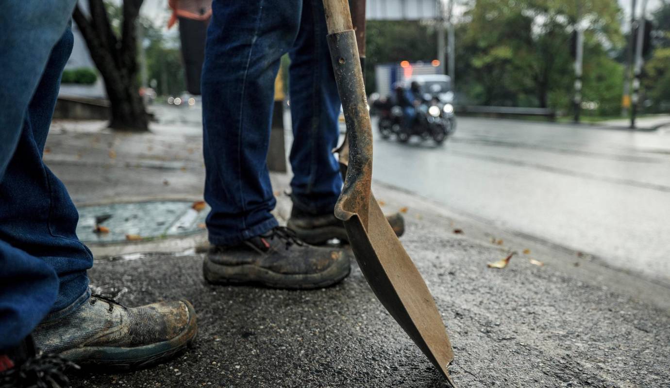 Los paleros se paran al borde de la calle con la pala en alto, como izando un arma, demostrando que no les pesa. Foto: Camilo Suárez Echeverry
