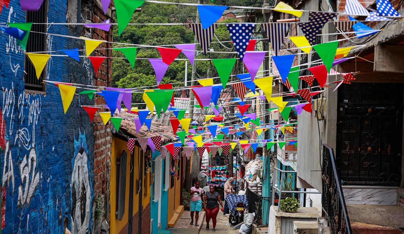 Los habitantes de una cuadra o un barrio se organizan para recolectar dinero destinado a la compra de materiales. Luego, en un ambiente festivo, iniciaba la elaboración de las largas tiras o triángulos multicolores que, colgadas de casa en casa, formaban túneles vibrantes que transformaban las calles en escenarios mágicos de Navidad. Foto Manuel Saldarriaga Quintero