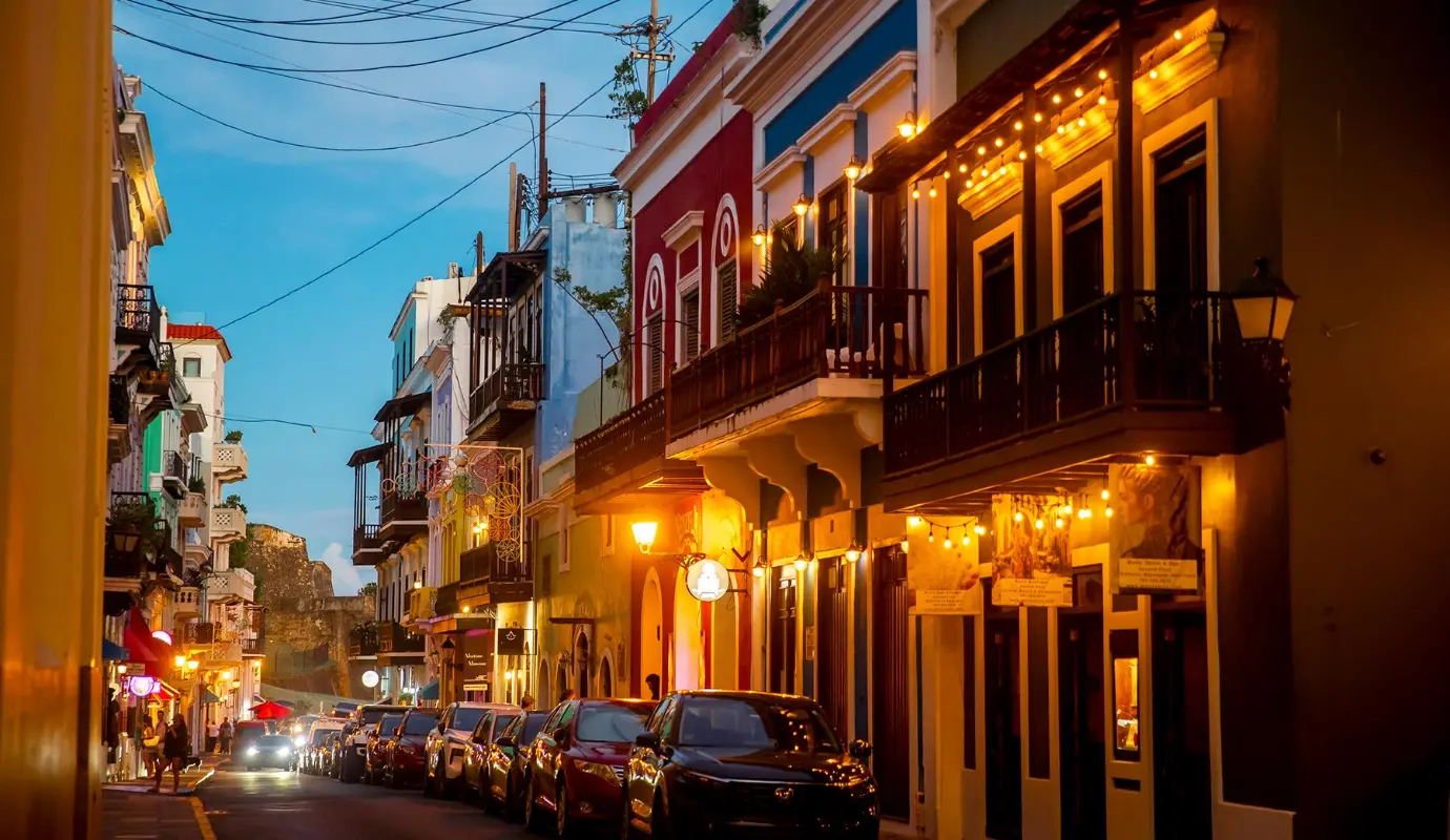 En la noche, las fachadas de casas coloniales, pintadas en tonos pastel, adquieren una nueva dimensión bajo la luz cálida, mientras que las tradicionales puertas de madera resaltan su textura y color. Foto: Juan Antonio Sánchez 