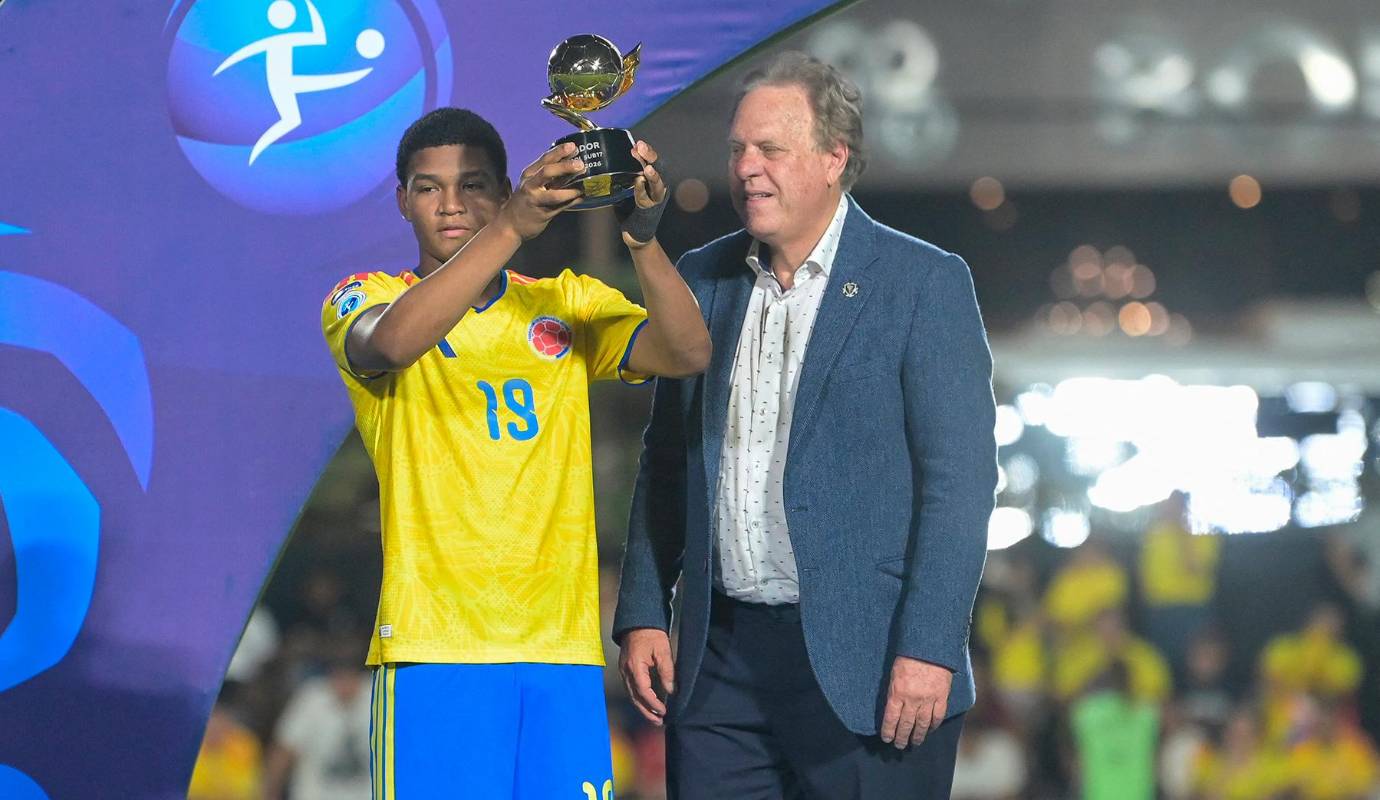 El delantero colombiano José Escorcia máximo goleador del torneo, sostiene el trofeo junto al presidente de la Federación Colombiana de Fútbol, ​​Ramón Jesurun, tras ganar la final del Campeonato Sudamericano Sub-17. Foto: AFP