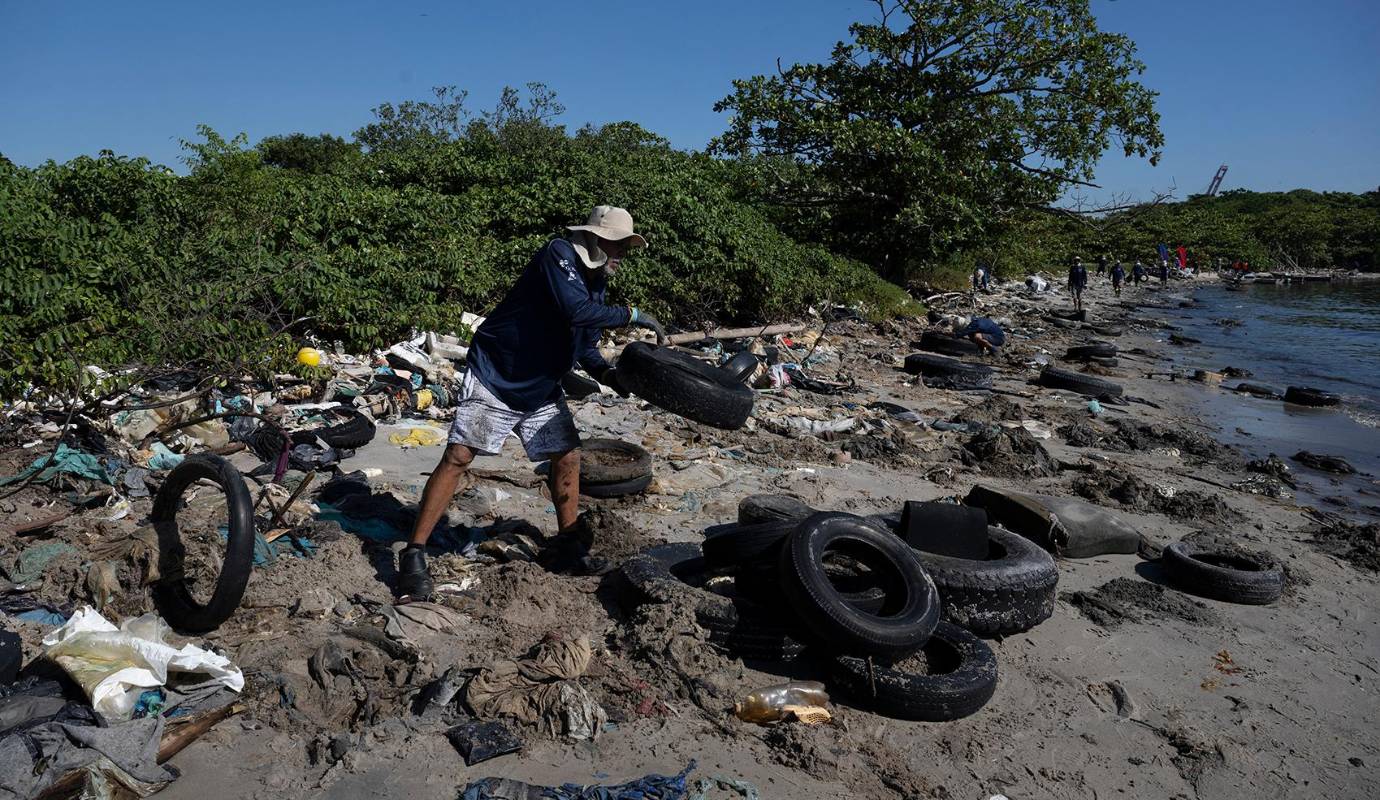 El islote Pombeba a escasos metros del puerto de Río de Janeiro, se ha convertido en símbolo de la devastadora contaminación que azota la Bahía de Guanabara. Sus playas, otrora refugio de vida marina, ahora están tapizadas por unas 80 toneladas de basura, un testimonio escalofriante del problema de saneamiento que enfrenta esta icónica bahía brasileña. Foto: AFP
