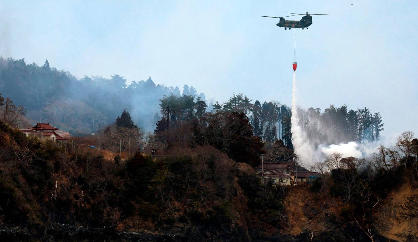 Las labores de extinción se llevan a cabo tanto en tierra como desde el aire, con el apoyo de helicópteros de las Fuerzas Aéreas de Autodefensa de Japón. Foto: AFP