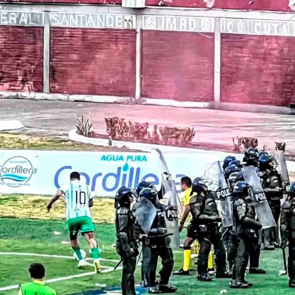 Este es uno de los cobros de tiro de esquina en los que Edwin Cardona es cuidado por un grupo de policías para protegerlo de los objetos que le lanzaban desde las tribua. FOTO CORTESÍA NACIONAL 