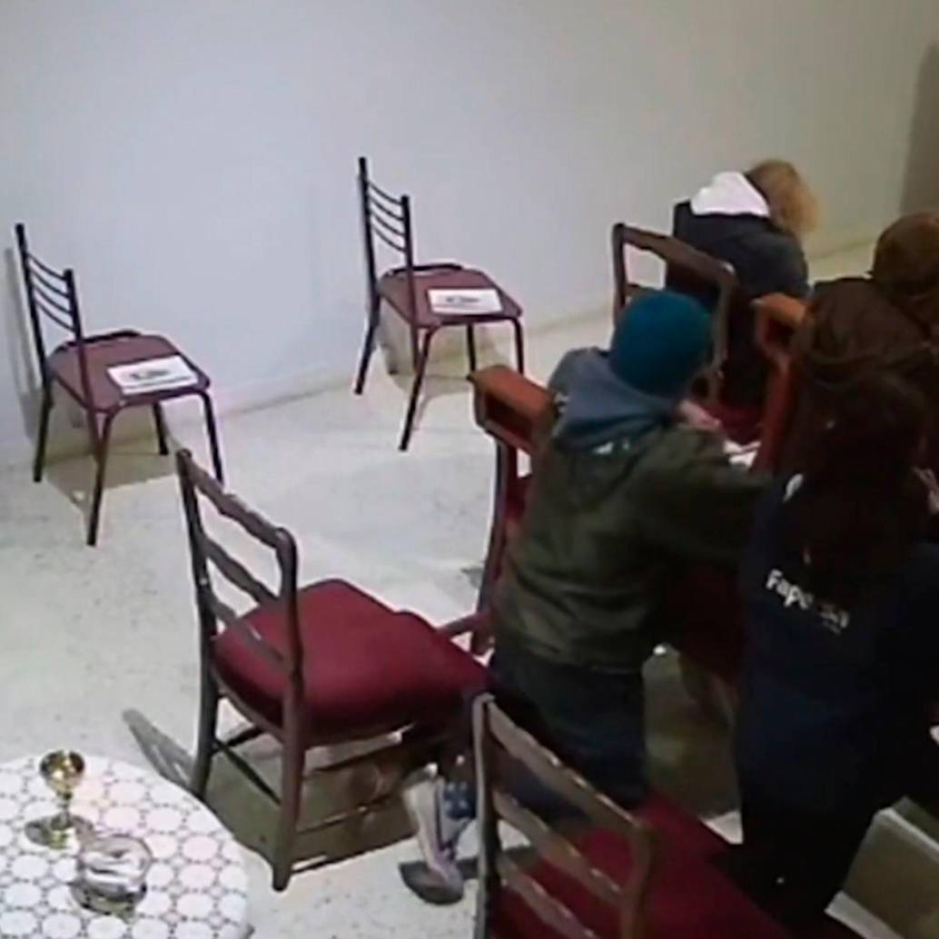 Momento en el que el hombre robó la cartera de una mujer mientras estaba arrodillado ante el altar. FOTO CAPTURA DE VIDEO