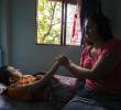Una mujer cuida de un paciente en su casa. Foto: EL COLOMBIANO