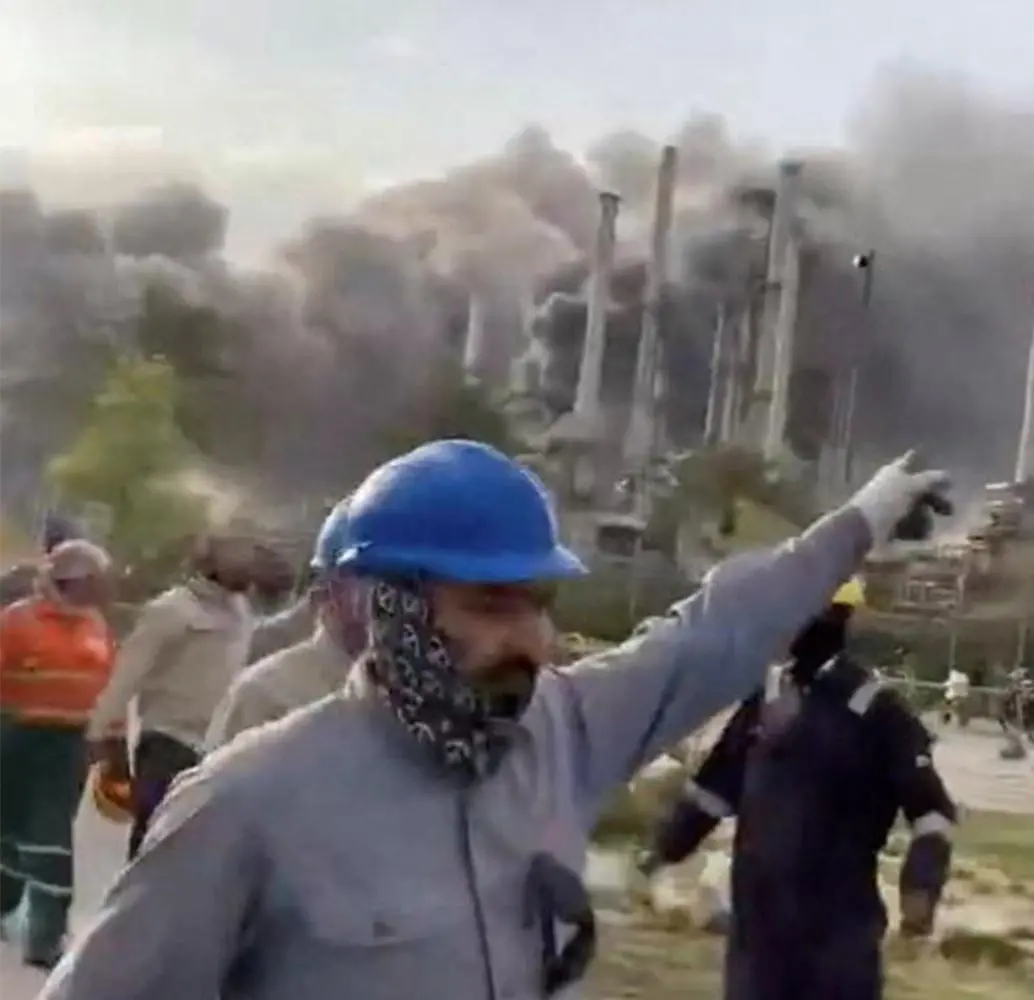 Los trabajadores evacúan el área alrededor de la refinería de petróleo Ras Tanura de Saudi Aramco mientras se eleva el humo luego de un reportado ataque con drones iraníes en Arabia Saudita. FOTO: Tomada de Al Jazeera.