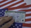 Permanent Resident Green card of United states of America on flag of USA. Above close up view.